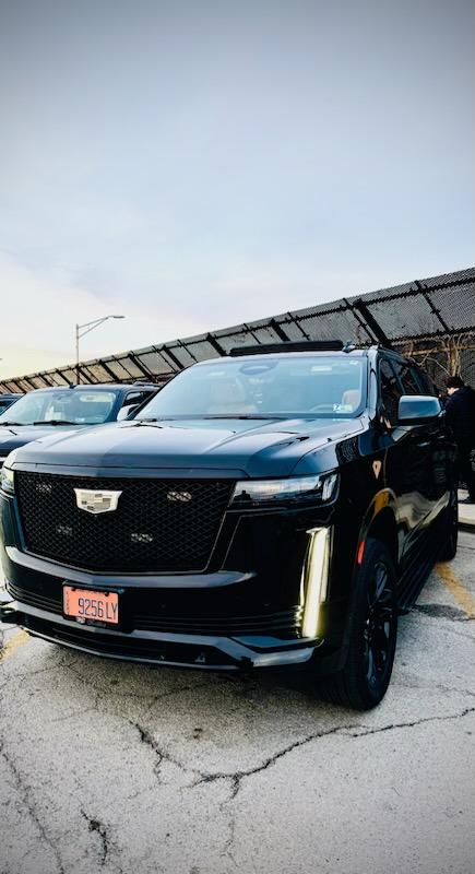 Black Cadillac SUV parked outdoors at sunset