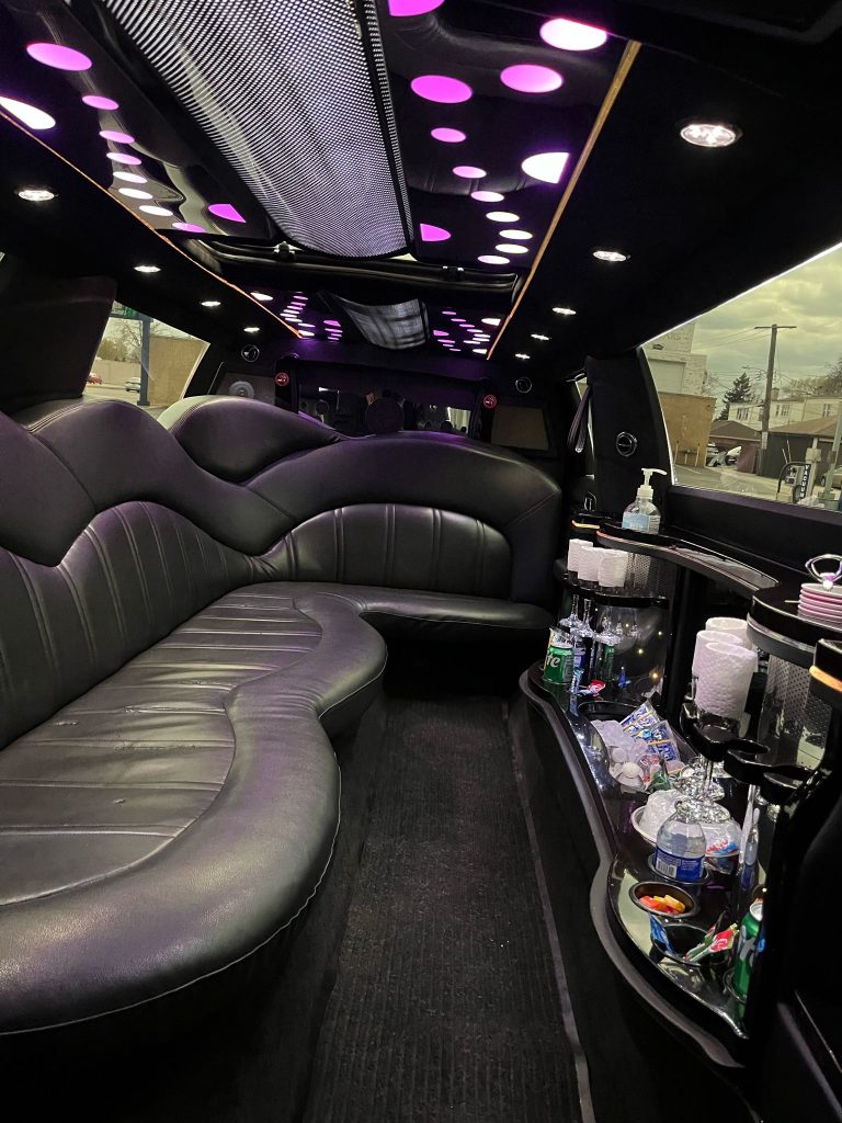 Luxurious limousine interior with purple lighting and bar area