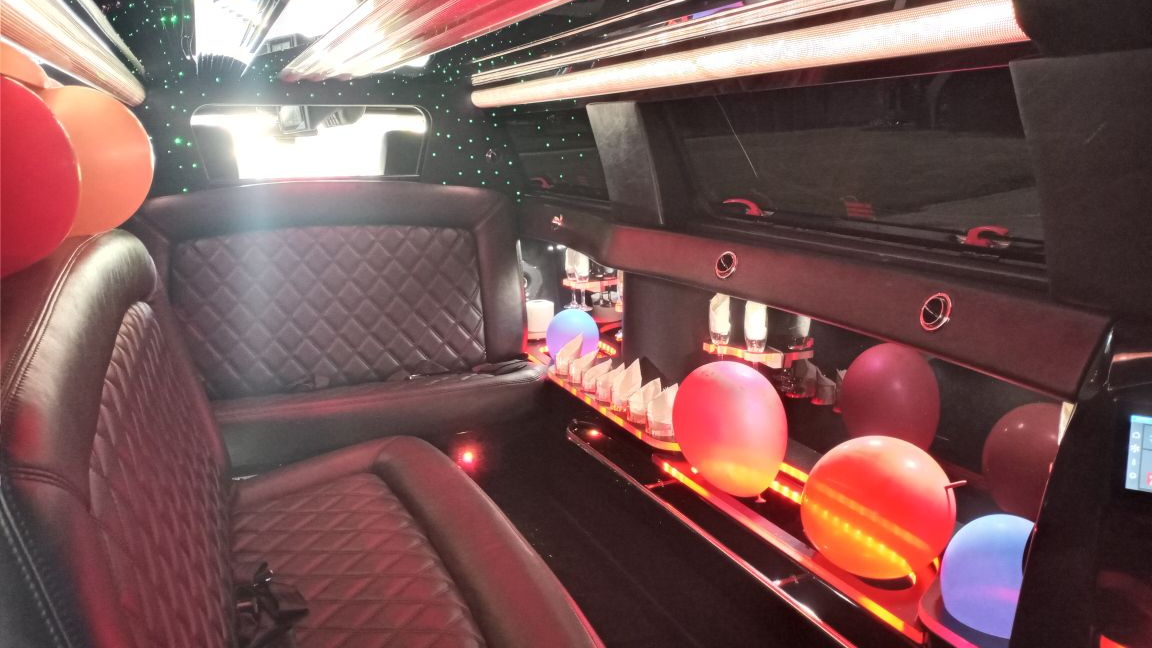 Luxury limousine interior with colorful balloons and lights