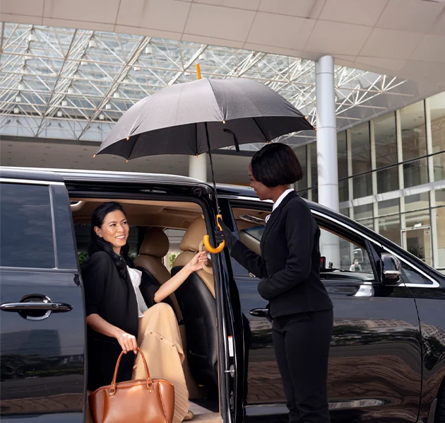 Black Car Limo Service in Chicago - Woman exits car with umbrella assistance.