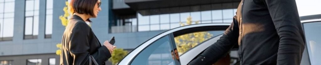 How Much Does A Chauffeur Cost? - Man opening car door for woman in business attire.