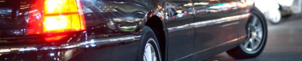 Should I Rent a Limo for New Year's Eve? - Close-up of a black car at night.