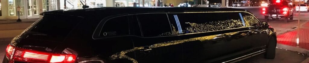 Should I Rent a Limo for a Concert or Sporting Event? - Black limousine parked at night with lights reflecting.