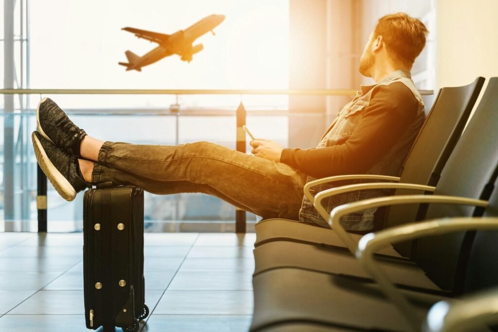 Will My Car Service Wait If Flight Delayed? - Traveler relaxing in airport, watching airplane takeoff.