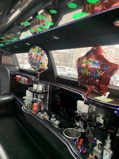 Birthday decorated limousine interior with balloons and drinks