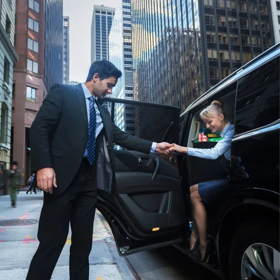 Man assists woman exiting car downtown.