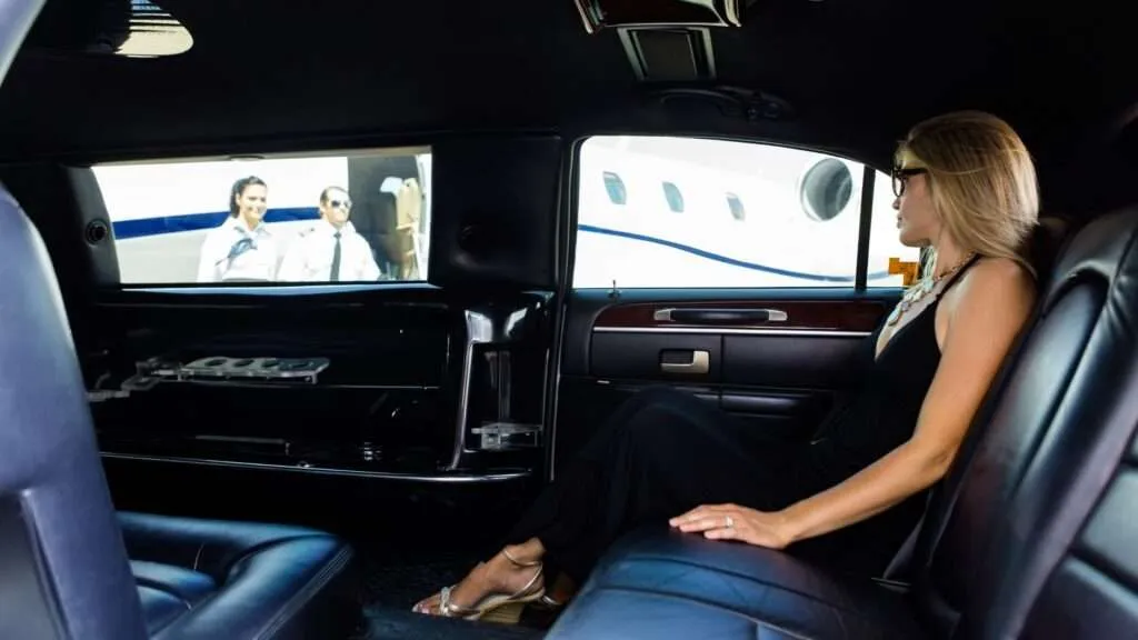 Woman in limousine near private jet